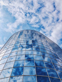 Low angle view of glass building against sky