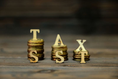 Close-up of stack coins with alphabets on table