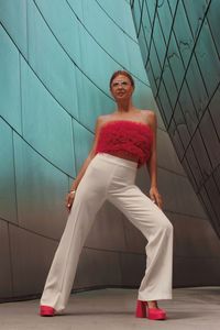 Full length of young woman  stands near a mirrored wall