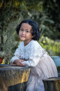 Portrait of young woman sitting on field