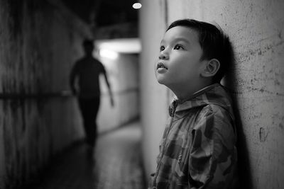 Side view of thoughtful boy standing in tunnel