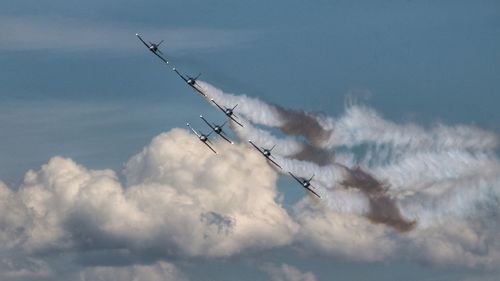 Low angle view of airshow against sky