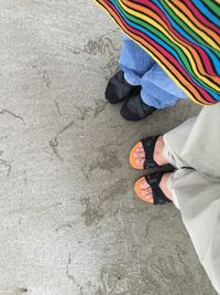 Low section of man standing on multi colored umbrella