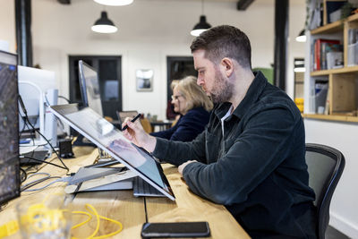 Architect working on graphics tablet at desk