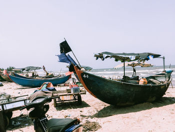 Fishing boats moored in sea against clear sky