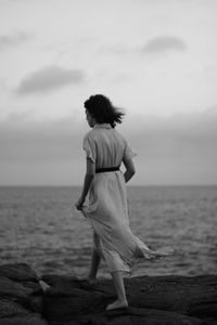 Rear view of woman standing on beach