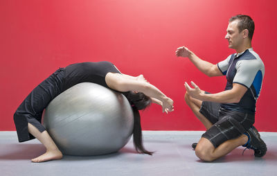 Personal trainer helping client in gym