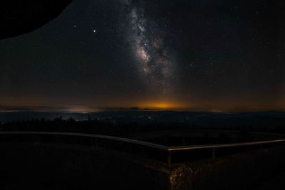 Illuminated landscape against sky at night