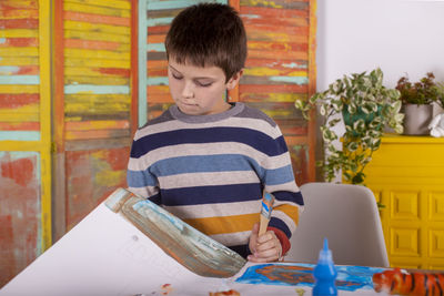 Boy creating artwork at home.