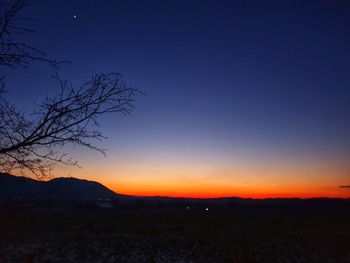 Scenic view of silhouette mountains against clear sky at sunset