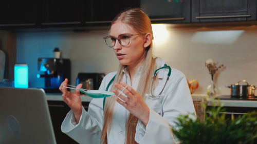 Female doctor wearing face mask at home