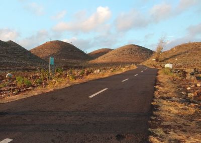 Road by mountain against sky