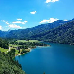 Scenic view of lake and mountains against blue sky