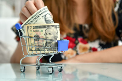 Close-up of woman holding coffee cup on table