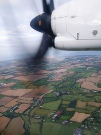 Aerial view of airplane flying over agricultural field