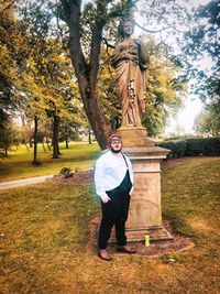 Full length portrait of young man standing in park during autumn