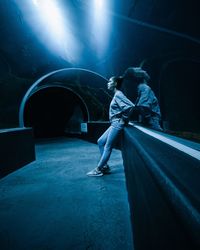 Side view of woman standing in aquarium