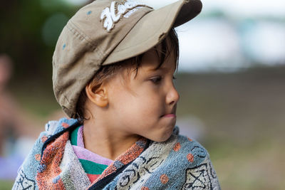 Close-up of boy wearing cap looking away