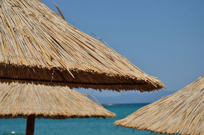 Beach straw parasols with blue sky and turquoise sea