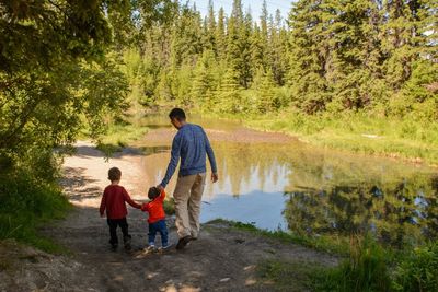 Father and two young children walking in nature