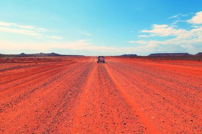 Dirt road passing through field