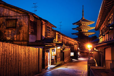 Street light by buildings and pagoda against sky