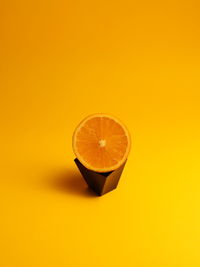 Close-up of orange fruit against yellow background