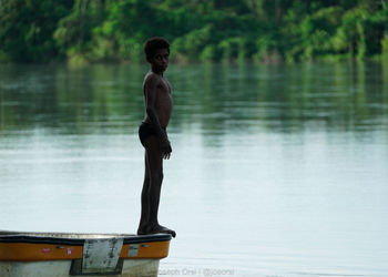 Full length of shirtless man standing in lake