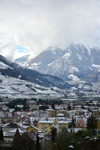 Aerial view of townscape and mountain against sky