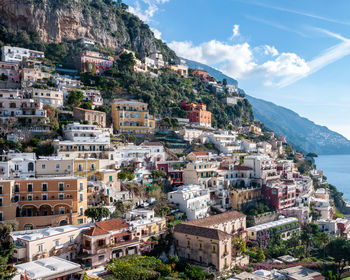 Aerial view of townscape by sea against sky