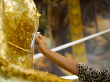Close-up of woman touching golden statue