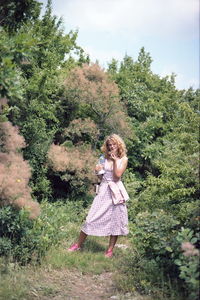 Side view of woman with arms raised