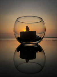 Close-up of electric lamp on table against sky during sunset