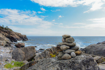 Rocks on sea shore against sky