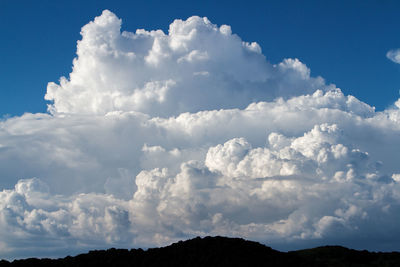 Dark mountains against majestic cumulus clouds