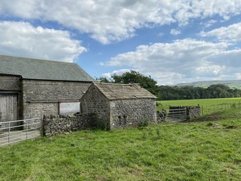 Old stone outbuildings, with trees, and hills, in the far distance in, newton, clitheroe, uk