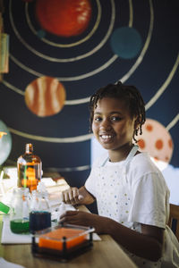 Portrait of smiling girl doing scientific experiment at home