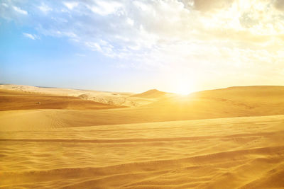 Scenic view of desert against sky during sunset