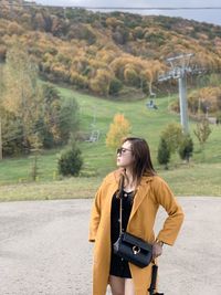 Young woman standing on road against mountain