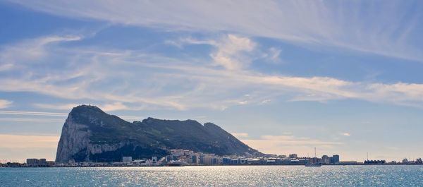 Sea by city against sky during sunset