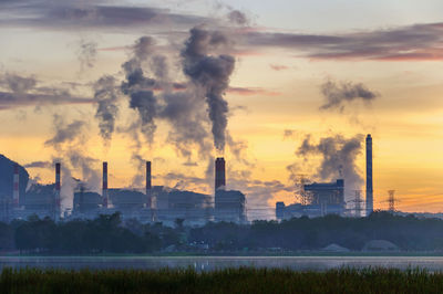 Coal power plant and steam from the flue in the beautiful morning among the mountains and lakes.