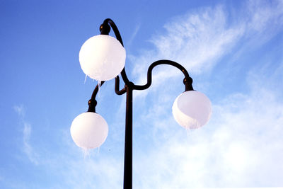 Low angle view of light bulbs hanging against sky