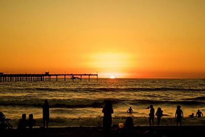 People at beach during sunset