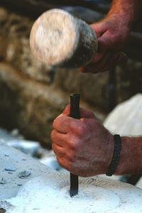 Midsection of man shaping rock