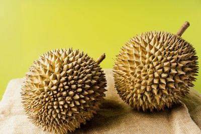 Close-up of pineapple on plant against yellow background