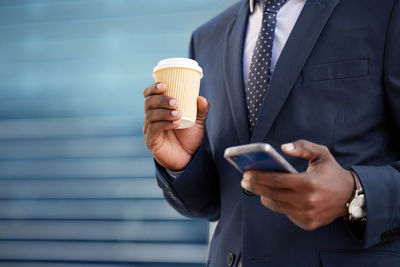 Midsection of businessman using mobile phone