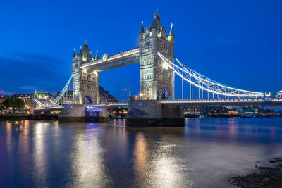 The tower bridge stretching over river thames in london, england.