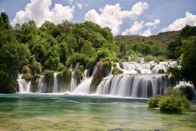 Scenic view of waterfall against sky