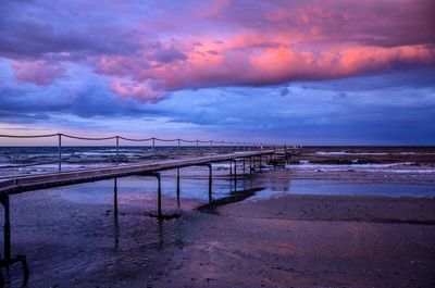 Pier over sea against sky during sunset