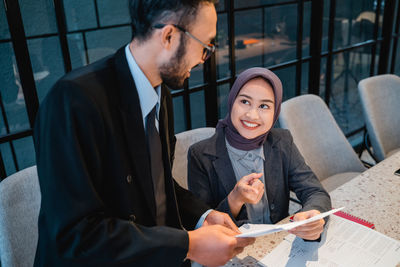 High angle view of smiling man talking with woman